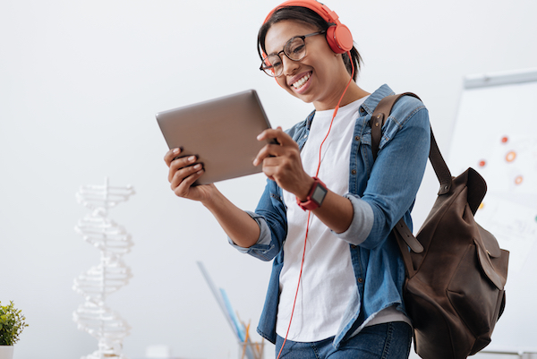 Happy delighted student holding a tablet